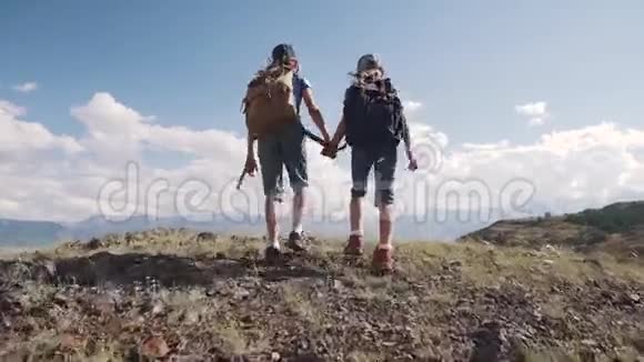 两个小女孩牵着手走在山上游客的孩子们沿着小路靠在路边视频的预览图