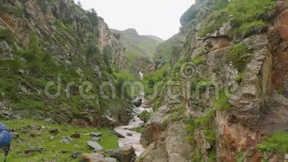 奥塞梯山脉两块岩石之间的山溪景观视频的预览图