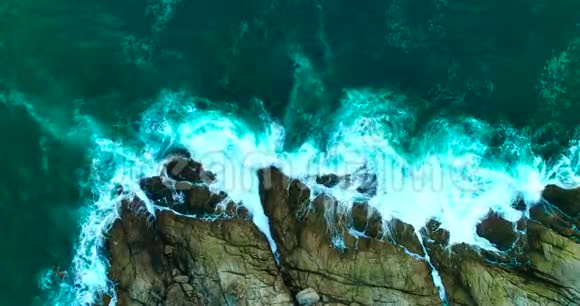 空中美丽的海浪岩石海岸线上有白色泡沫视频的预览图