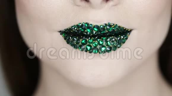 绿色的嘴唇覆盖着莱茵石绿色口红的漂亮女人视频的预览图