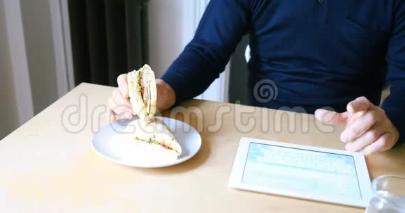 4k客厅早餐时使用数码平板电脑的男子视频的预览图