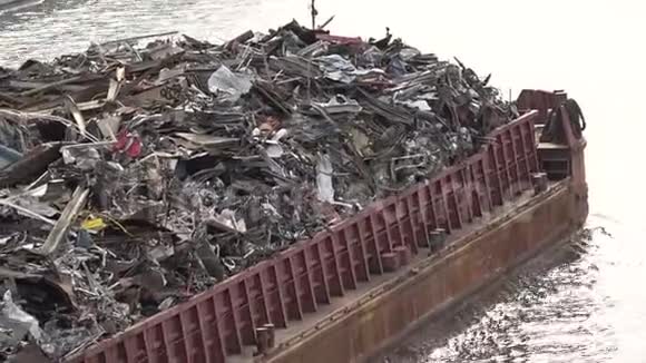 满是金属废料的驳船沿着河游视频的预览图