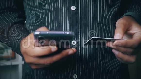 一个男人用信用卡和手机付款视频的预览图