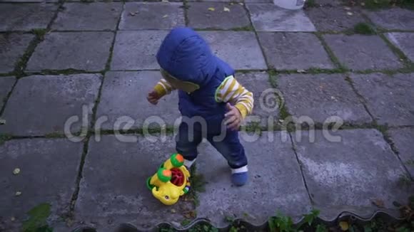 穿背心的孩子在街上的瓷砖上爬视频的预览图
