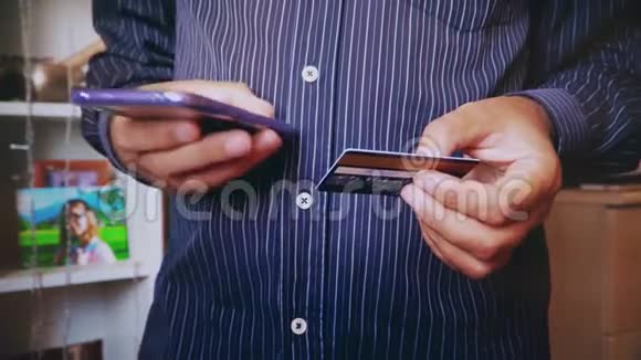 一个男人用信用卡和手机付款视频的预览图