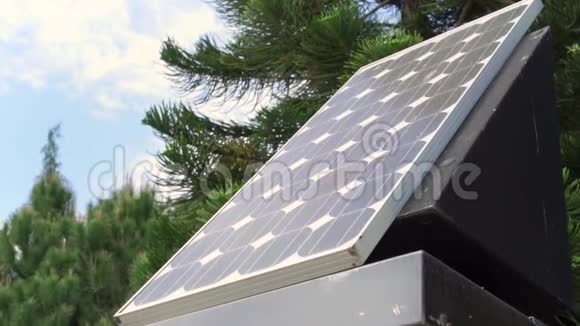 太阳能电池板覆盖着蓝色多云的天空和绿色的树木户外新的替代能源技术视频的预览图