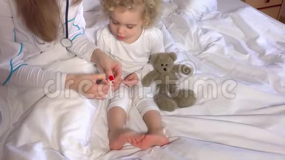 女医生双手粘在床上可爱的小女孩腿上视频的预览图