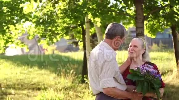 爷爷在树的背景上拥抱奶奶视频的预览图