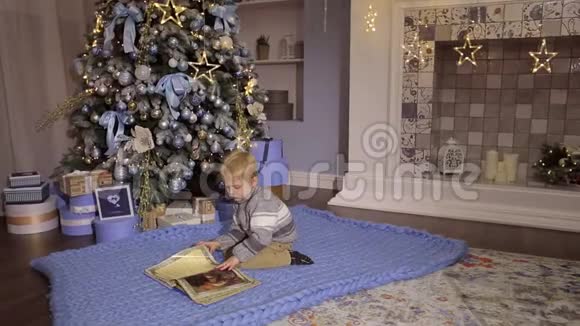 小男孩在圣诞树附近看书视频的预览图