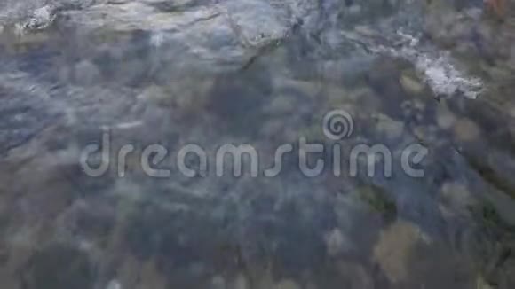 透明的水在一条山河里美丽地流淌着底部可见的石头视频的预览图