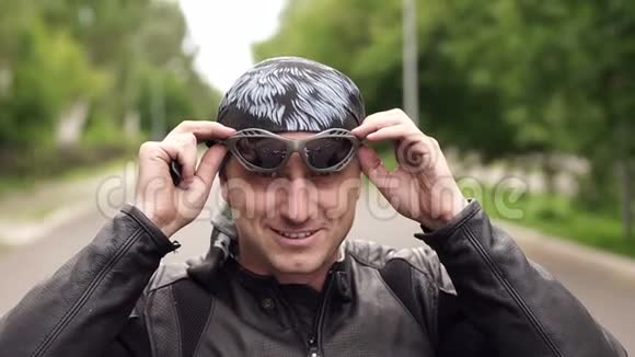 穿皮夹克的摩托车手戴上太阳镜视频的预览图