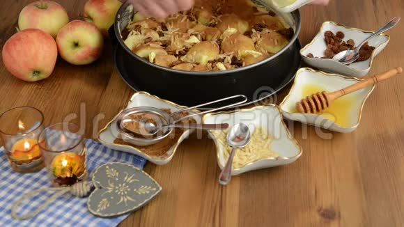 苹果派烘焙把葡萄干洒在生苹果派上此外还有蜂蜜肉桂糖杏仁等成分视频的预览图
