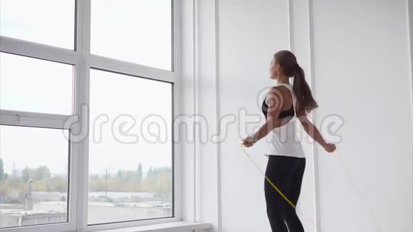 年轻而有运动能力的女人热身肌肉女士快速地跳上绳子视频的预览图