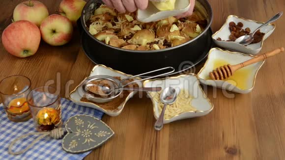 苹果派烘焙把葡萄干洒在生苹果派上此外还有蜂蜜肉桂糖杏仁等成分视频的预览图