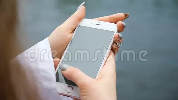 一位留着长指甲和头发的女士在手机特写中打印了一条信息欧洲女孩天生就会使用智能手机视频的预览图