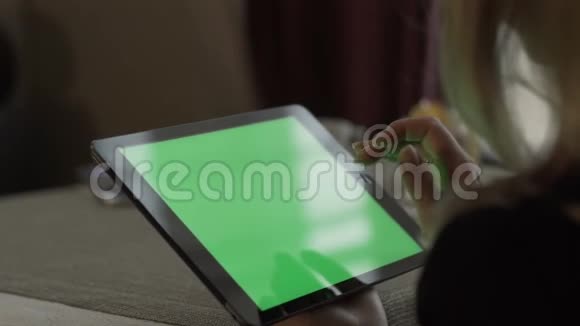 女性手在绿色屏幕平板电脑上打字坐在咖啡馆的桌子上视频的预览图
