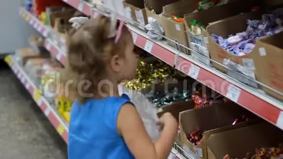 超市里的孩子买糖果和糖果购物商店视频的预览图