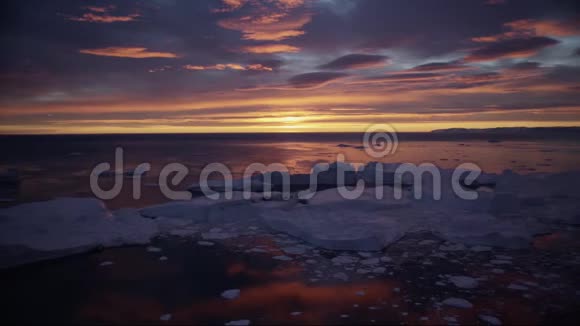 北极自然景观与冰山在格陵兰冰峡湾与午夜太阳日落视频的预览图