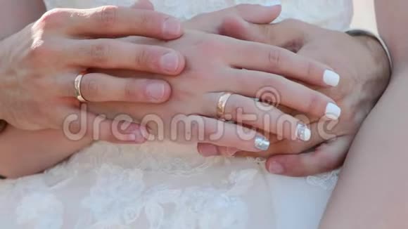 新婚夫妇的双手用戒指轻轻地抚摸着对方视频的预览图