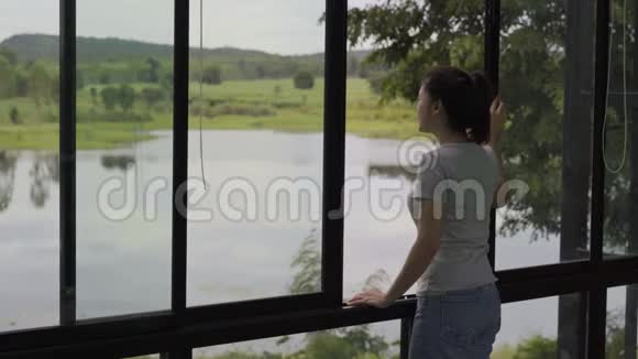 女人打开窗户寻找大自然视频的预览图