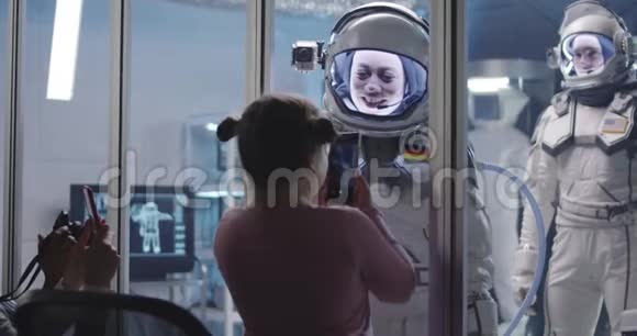宇航员在出发前与女孩配对手掌视频的预览图