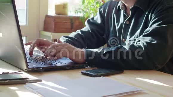 男人手使用笔记本电脑在家里的桌子上有空白的屏幕视频的预览图
