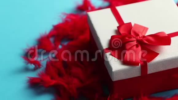 带有礼物的盒子系在红色羽毛上的丝带上视频的预览图