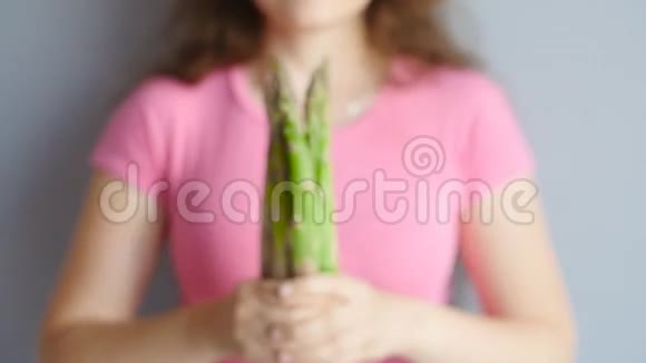 一个女人手里拿新鲜绿芦笋视频的预览图