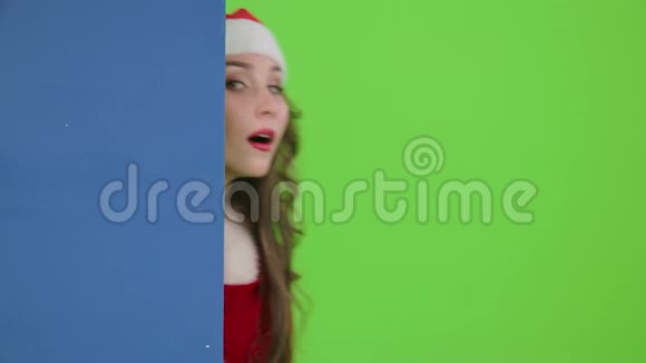 圣诞老人助理看着外面的蓝板伸出大拇指绿色屏幕慢动作视频的预览图