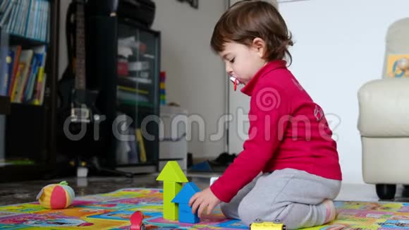 婴儿在地毯地板上玩耍的轮廓家庭积木视频的预览图