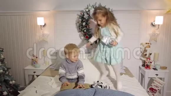 两个孩子在床上跳来跳去过圣诞节视频的预览图