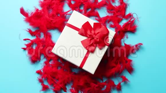 带有礼物的盒子系在红色羽毛上的丝带上视频的预览图