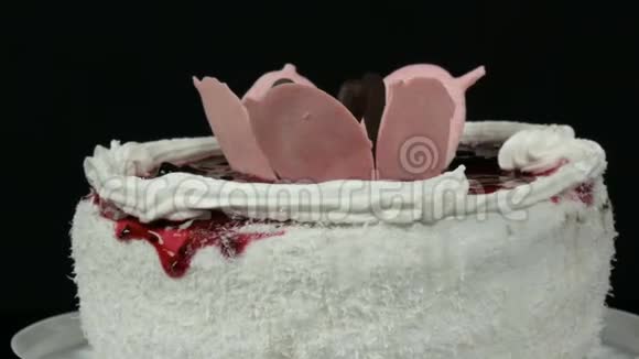 美丽时尚的甜鲜白蛋糕樱桃果酱装饰在顶部奶油和椰子薯片旋转视频的预览图