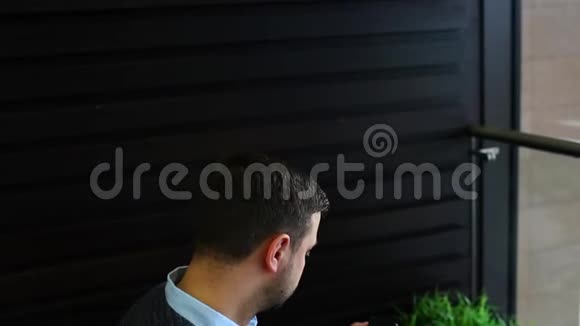 freelancer商人在咖啡馆里用屏幕上的图表在笔记本电脑上工作检查智能手机信息应用程序视频的预览图