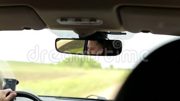 车后视镜中男人的肖像视频的预览图