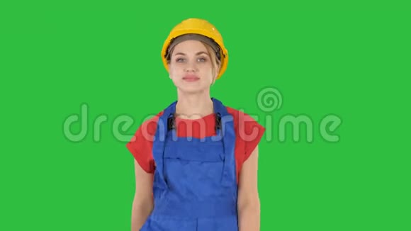 穿着黄色硬帽走在绿色屏幕上的年轻女人Chroma键视频的预览图