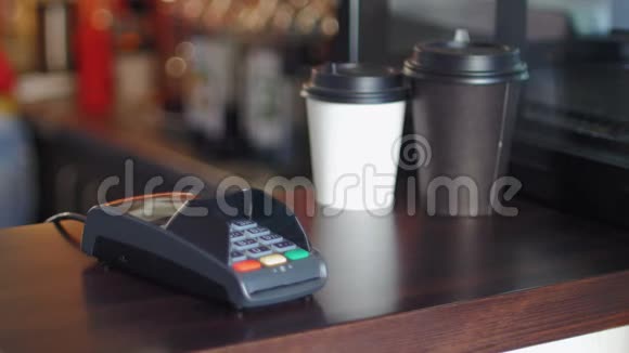 咖啡馆里穿着白色夹克的女商人用智能手表和终端机来支付价格视频的预览图