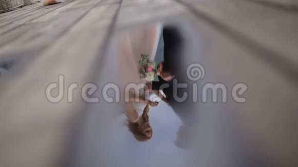 新婚夫妇的浪漫照片在水坑里倒影慢动作视频的预览图