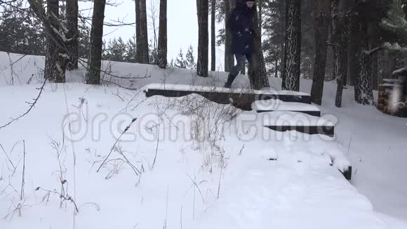 在冬天的公园里女人走下满是雪的楼梯4K视频的预览图