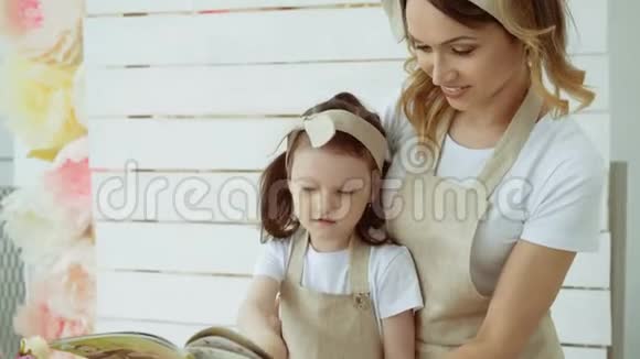 一个小女孩和她的母亲用搅拌器搅拌面粉妈妈教女儿揉面团视频的预览图
