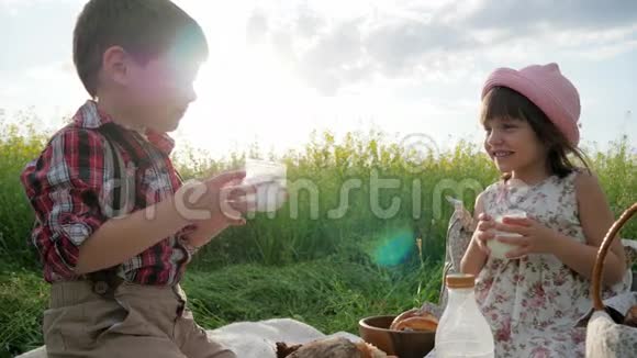 有花背景的朋友去野餐背光的牛奶杯儿童叮当的眼镜家人享受牛奶视频的预览图