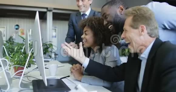 在现代同事中心的办公桌前为女企业家的成功欢呼快乐的成功视频的预览图