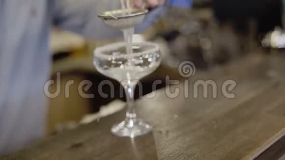 将果汁通过筛子倒入玻璃杯中4K视频的预览图