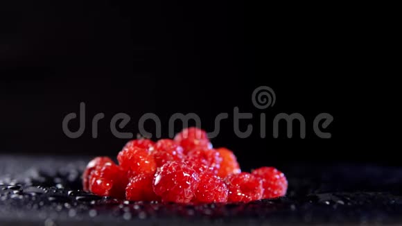 带有水滴的树莓在黑色背景下移动视频的预览图