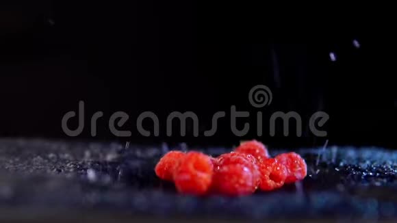 带有水滴的树莓在黑色背景下移动视频的预览图