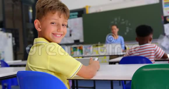快乐白人小学生在教室里看摄像机的后视图视频的预览图