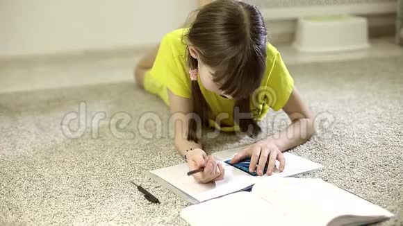 坐在房间地毯上做作业的少女视频的预览图