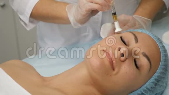 美的概念正在进行的中间治疗程序美容师拿着注射器注射与年轻的人一起工作视频的预览图