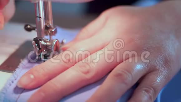 裁缝的手降低了缝纫机的针头她开始缝衣服视频的预览图