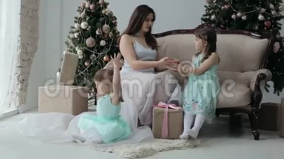 新年快乐的孩子和妈妈在玩圣诞礼物视频的预览图